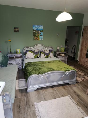 a bedroom with a large bed with a green blanket at Liana's house 2 in Perama
