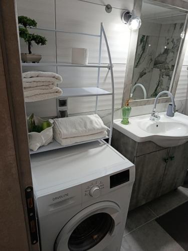 a washing machine in a bathroom next to a sink at Liana's house 2 in Perama