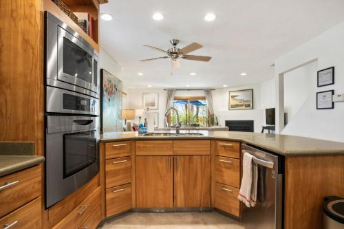 a kitchen with wooden cabinets and a ceiling fan at Bird's Nest -2BR Downtown Saugatuck Walkable in Saugatuck