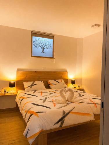 a bedroom with a bed with a tree on the wall at Apartma Arbores in Sveti Jurij ob Ščavnici