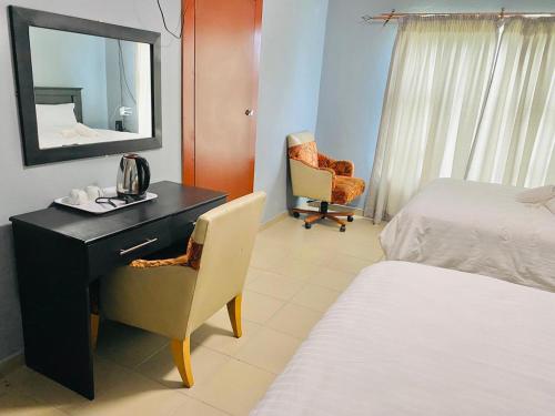 a bedroom with a desk and a bed and a mirror at Mabutane Villas in Badplaas