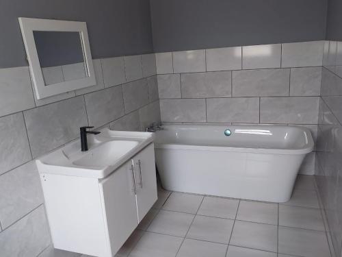 a bathroom with a sink and a bath tub at Mabutane Villas in Badplaas