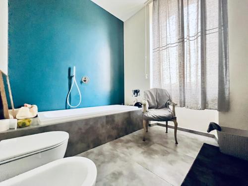 a bathroom with a tub and a toilet and a chair at Maison Martina in Rivoli