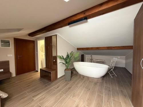 a bathroom with a white bath tub in a room at Guest House Pod Slavnikom in Podgorje