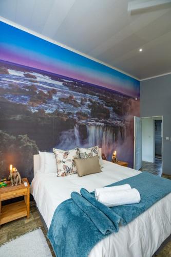 a bedroom with a bed with a large painting on the wall at Wild Villas in Victoria Falls