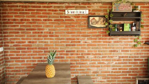 a pineapple sitting on a table in front of a brick wall at La Casa de Lu cerca de Volcanic park in San Martín Ojo de Agua