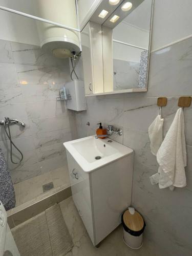 a white bathroom with a sink and a mirror at House1890 in Kula
