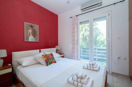 a bedroom with a white bed and a red wall at Casa Miniera in Linopótis