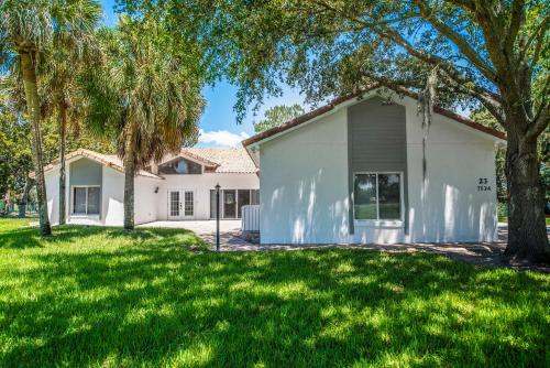 a white house with trees in front of it at SWISS 23 - Lake Stephanie in Clermont