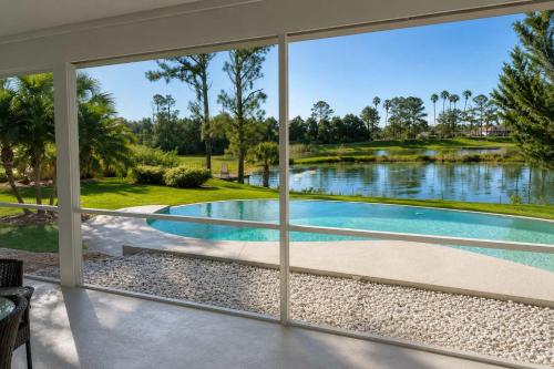 a view of a swimming pool from a house window at SWISS 28 - Lake Stephanie in Clermont