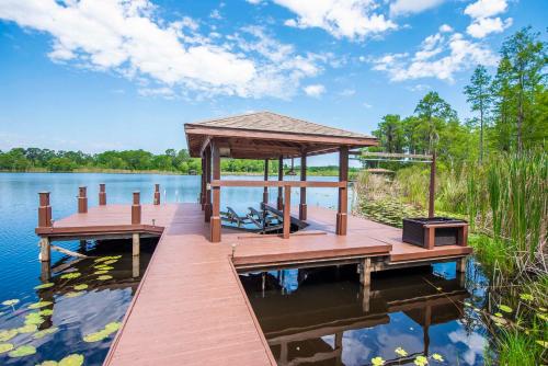 a wooden dock with a gazebo on a lake at SWISS 105 - Lake Olsen in Clermont