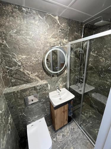 a bathroom with a sink and a toilet and a mirror at ABBA Hotel in Kyiv