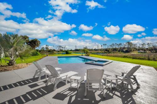 a patio with a table and chairs next to a pool at SWISS 56 - Lake Denise in Clermont