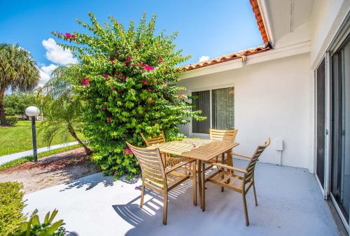 a wooden table and chairs on a patio with a tree at SWISS 57 - Lake Denise in Clermont