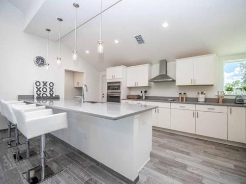 a large kitchen with white cabinets and a large island at SWISS 14 - Lake Stephanie in Clermont