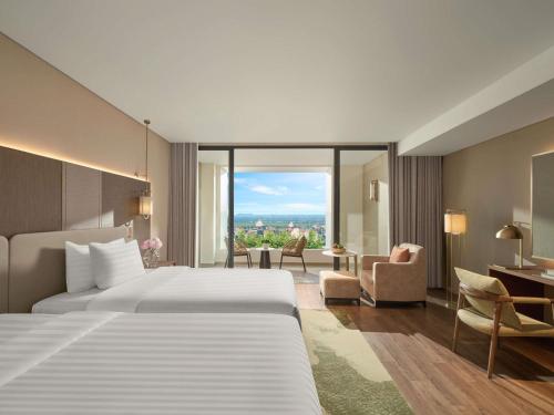 a hotel room with a bed and a large window at Pullman Ninh Binh in Ninh Binh