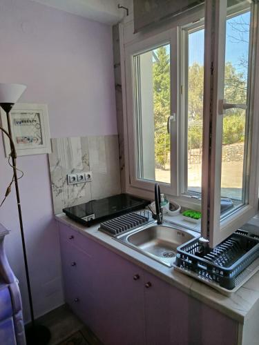a kitchen with a sink and a window at liana house 3 in Skála Loutrón