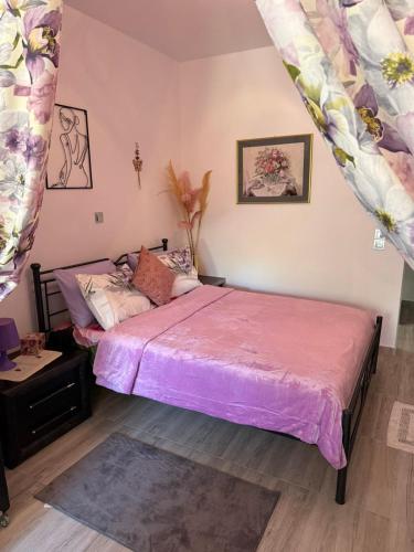 a bedroom with a bed with a pink bedspread at liana house 3 in Skála Loutrón