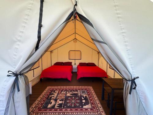 two beds in a tent with a rug at Ruby Glamping tent - tent site #9 in Klamath