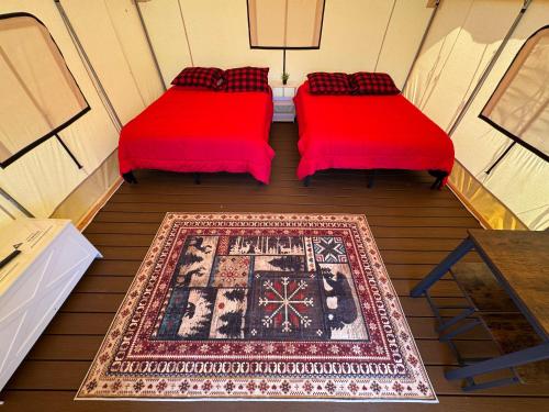 two beds in a room with a rug on a floor at Ruby Glamping tent - tent site #9 in Klamath