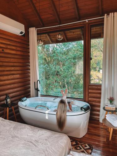 a girl in a bath tub in a bedroom at Refugio Poço do Cânion in Alfredo Wagner