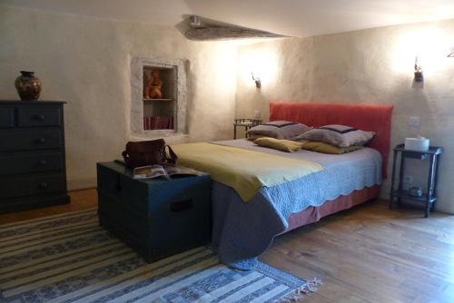 a bedroom with a bed with a red head board at La Mouline de Belin in Lectoure