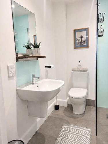 a white bathroom with a sink and a toilet at Steam Mill in Wellow