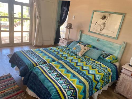a bedroom with a large bed with a colorful comforter at Oceanview Sunrise Beach Villa in Rocklands
