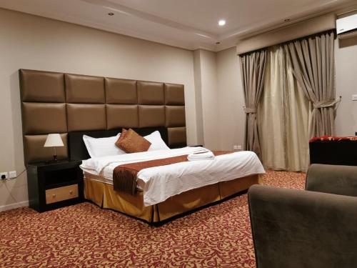 a bedroom with a large bed with a large headboard at ashbona suites in Riyadh