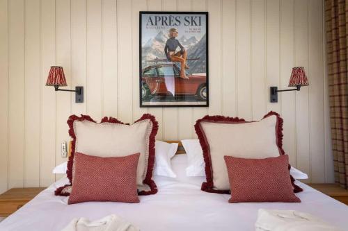a bed with two pillows and a picture of a car at 3BR Central Pool Sauna Gym & Views in Verbier