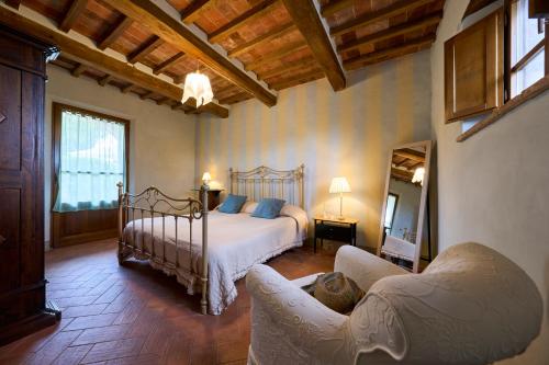 a bedroom with a bed and a couch in a room at Conca d'Oro casale con piscina privata in Foiano della Chiana