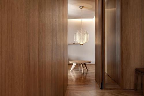 a hallway with a table and a chandelier at Woodline Suite in Luxembourg
