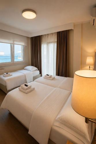 two beds in a hotel room with a window at Hotel Avra in Perea