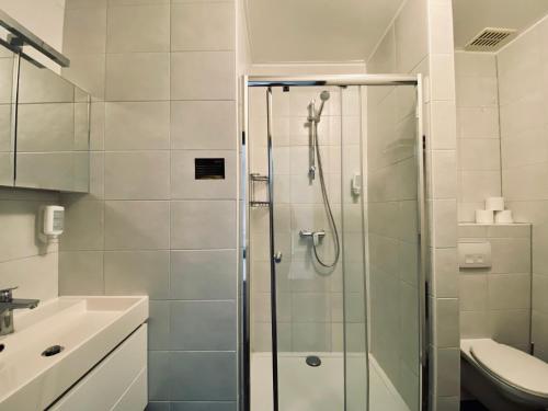 a bathroom with a shower and a toilet and a sink at Hotel Pommerloch in Pommerloch