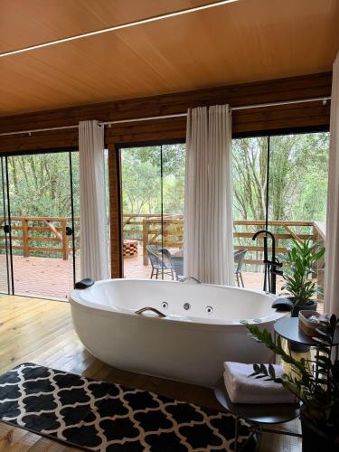 a large white tub in a room with a deck at Cabana Penélope in Alfredo Wagner
