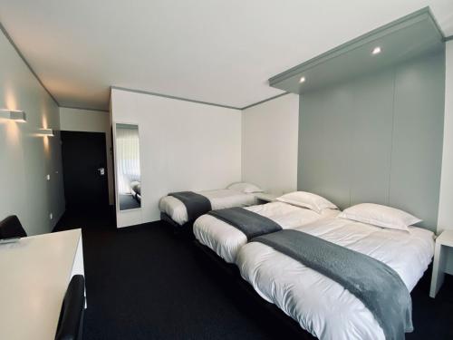 two beds in a room with white walls at Hotel Pommerloch in Pommerloch