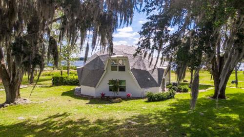 a small white house in a field with trees at Sumner Lake House 3B in Clermont