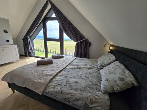 a bedroom with a bed with a large window at Panorama Sudety in Nowa Bystrzyca