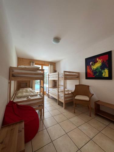a room with three bunk beds and a chair at Moilles 13 in Arni Alp