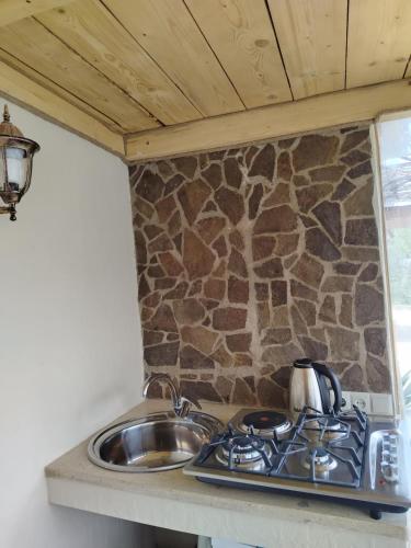 a kitchen counter with a sink and a stove at Green Park Guest House in Dilijan