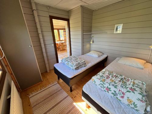 two twin beds in a room with a porch at Klobbars Gästhem o Stugor in Kökar