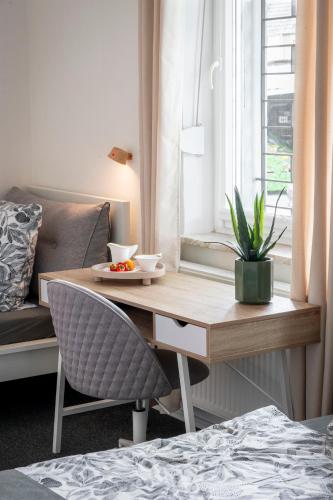 a room with a desk and a chair and a table and a window at Jans 4 Personen Work Apartment mit Küche P WLAN Code NRW Veltins Arena in Herten