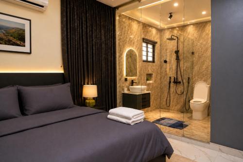 a bedroom with a bed and a bathroom with a shower at The COZY CREST in Akure