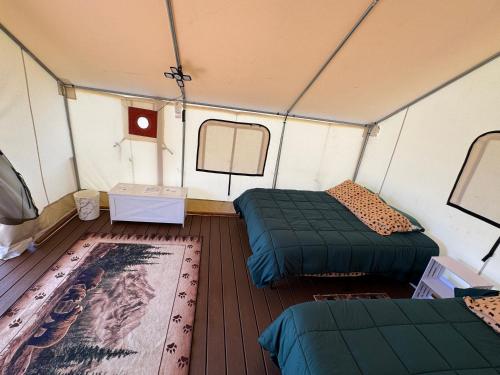 a room with two beds and a rug in a tent at Emerald - Glamping tent in Klamath