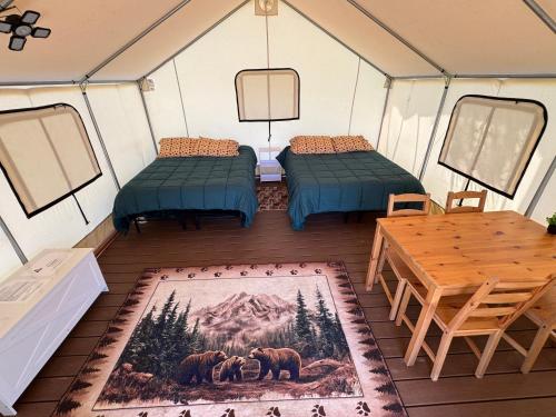 a room with two beds and a table in a tent at Emerald - Glamping tent in Klamath