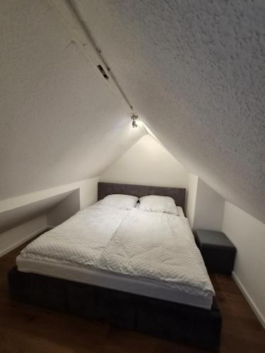 a white bed with two pillows in a room at Pottblick Oberhausen in Oberhausen