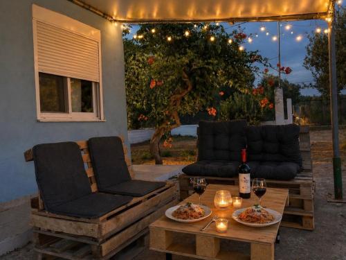 a patio with two chairs and a table with glasses of wine at Wooden Loft 3min Walk to Beach in Alexandroupoli