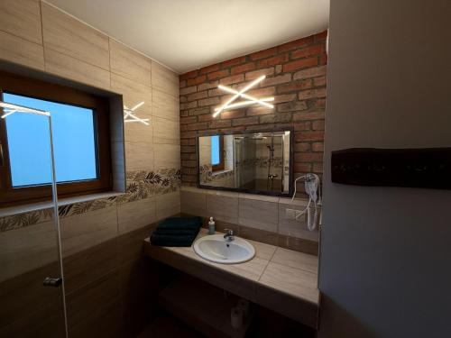 a bathroom with a sink and a mirror at Mazurskie El Dorado in Mikołajki