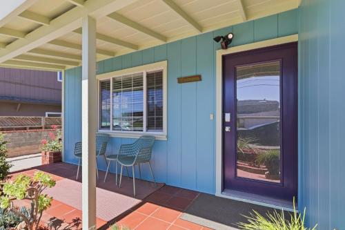 a blue house with a purple door and chairs at The Eastman House in Santa Cruz