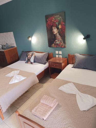 a room with two beds and a painting on the wall at Hotel Manos in Paralia Katerinis